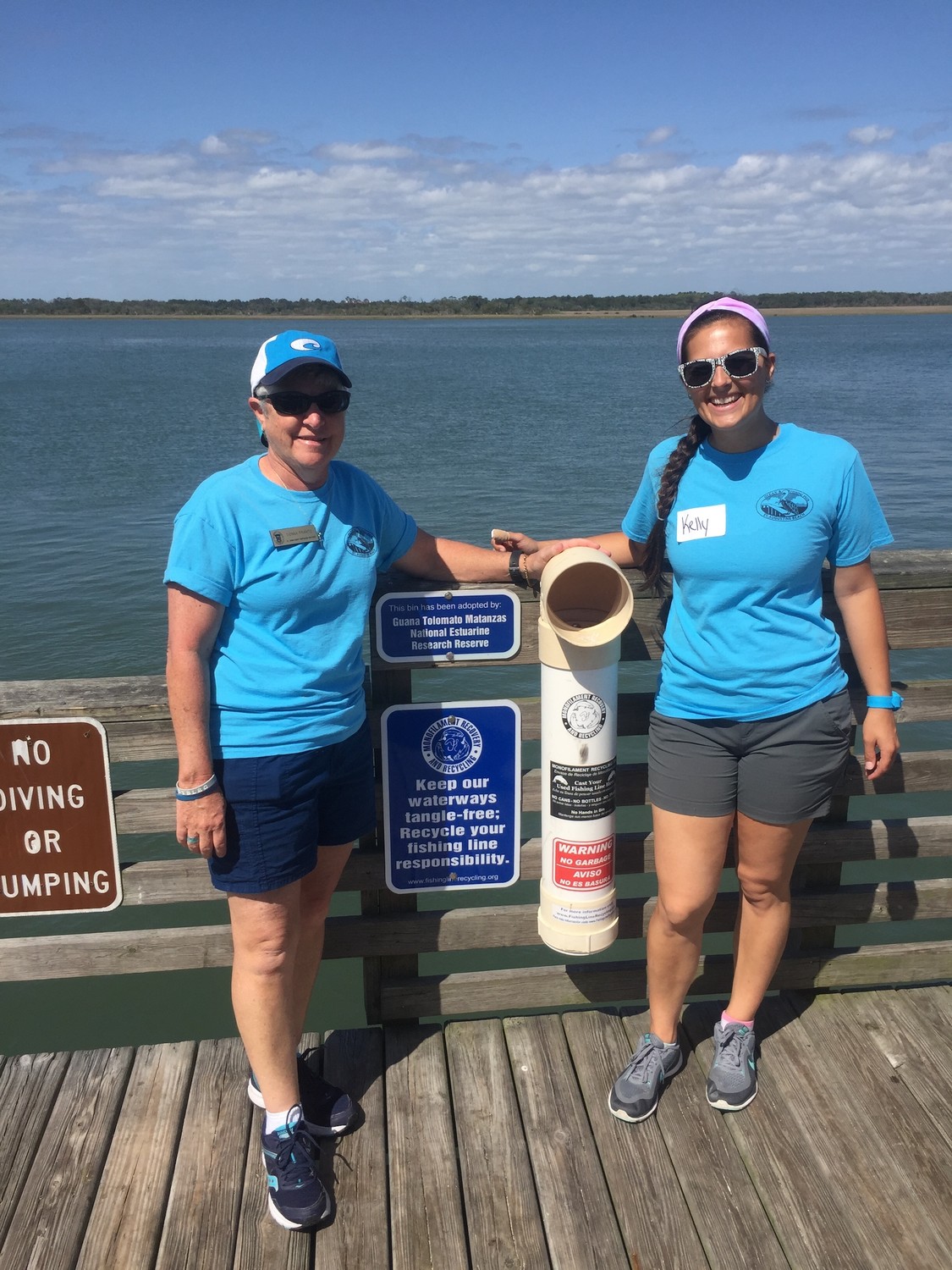 St. Johns County Parks and Recreation staff members Donna Frantz (left) and Kelly Ussia stand next to a Monofilament Recovery and Recycling Program bin.